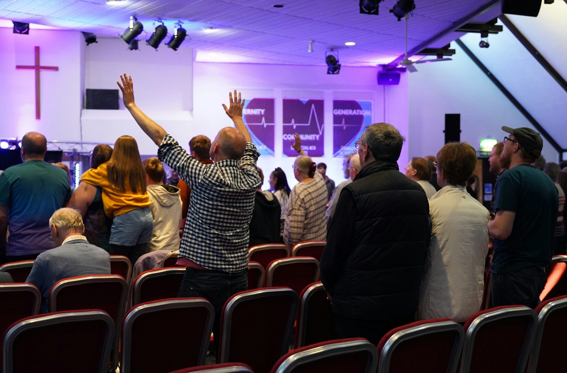 a group of people standing in a room with their hands in the air